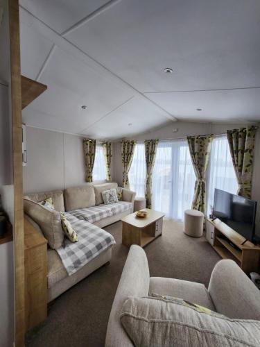 a living room with two couches and a tv at Dees hot tub breaks at Tattershall Lakes Jet Ski 4 in Tattershall