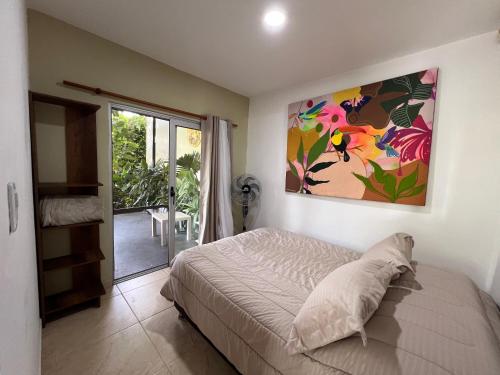 a bedroom with a bed and a painting on the wall at Casa de Ali in Pereira