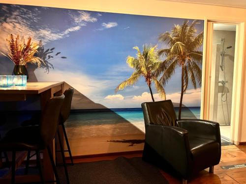 a room with a mural of the ocean and palm trees at Beach House met badkamer, boxspring & airco in Schoonebeek