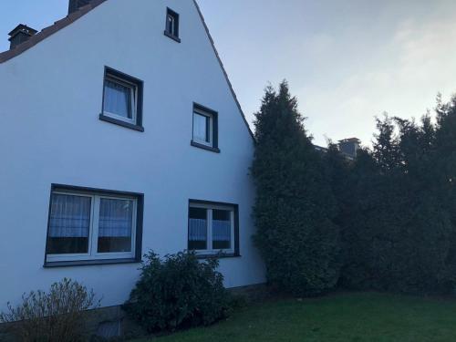 a white house with three windows and a yard at Schöne Wohnung mit TV, WLAN und Küche - Anna in Werne an der Lippe