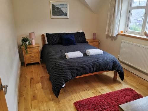 a bedroom with a bed with two towels on it at Unbeatable Llanberis Location, Detached with Parking, Snowdon Views. in Llanberis