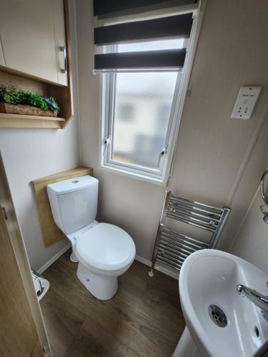 ein kleines Bad mit WC und Waschbecken in der Unterkunft Dees hot tub breaks at Tattershall Lakes Jet Ski 4 in Tattershall