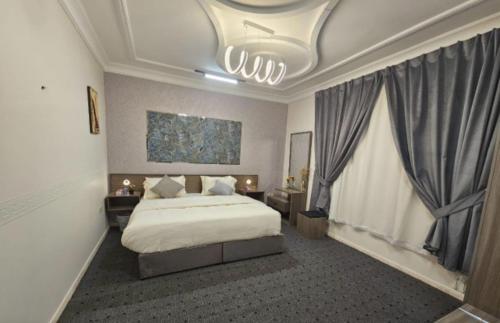 a bedroom with a bed and a large window at استيديو حياة الفيصلية دخول وخدمة ذاتيه in Al Rass