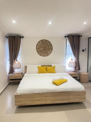 a bedroom with a large bed with yellow pillows at Spacious 2-Bedroom Mediterranean-Inspired Home in Ikeja