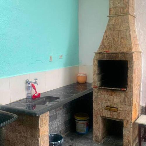 cocina con horno de piedra y fregadero en Recanto Caiçara en Solemar