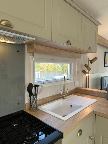 a kitchen with a sink and a window at Luxury Lakeside Lodge, Hot Tub & Private Fishing in Tattershall
