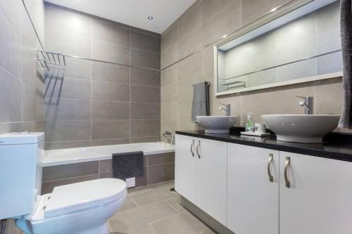 a bathroom with a toilet and two sinks and a tub at 3 bedroom villa, 10min walk to shops, bars & beach in Luz