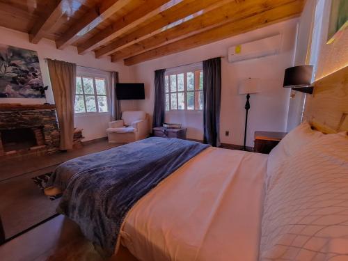 een slaapkamer met een groot bed en een open haard bij Finca la concordia: Hotel frutos del bosque in Zacatlán