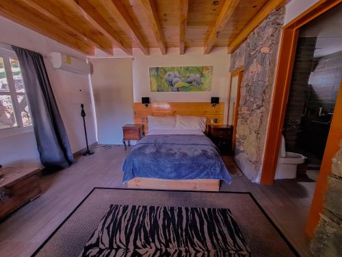 een slaapkamer met een bed en een stenen muur bij Finca la concordia: Hotel frutos del bosque in Zacatlán