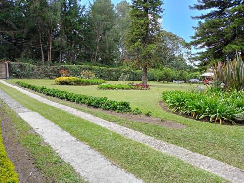 a walkway in a park with grass and flowers at CASA CAMPESTRE EN LLANOGRANDE in Rionegro