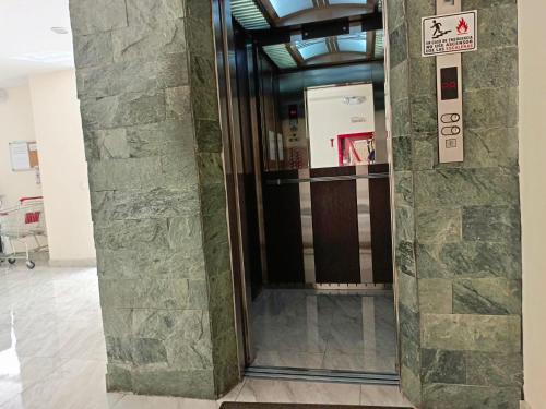 an elevator in a building with a stone wall at CENTRAL Apartment, 3Beds - Balcony - Parking - 6thFLOOR in Quito