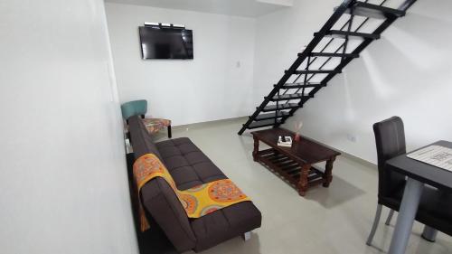 uma sala de estar com um sofá e uma escada em Depto Lionel em Río Gallegos