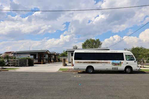 a white bus parked in front of a building at Kenilworth Country Cabins in Kenilworth