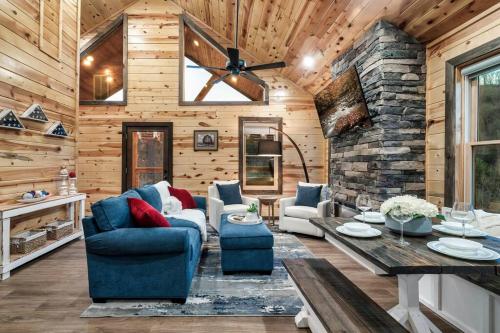 uma sala de estar com um sofá azul e uma parede de pedra em Cozy Family Cabin w/ Hot Tub in Sevierville em Sevierville