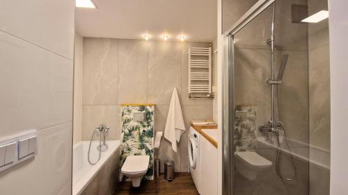 een badkamer met een douche, een toilet en een wastafel bij Apartament Nepomucen in Przemyśl