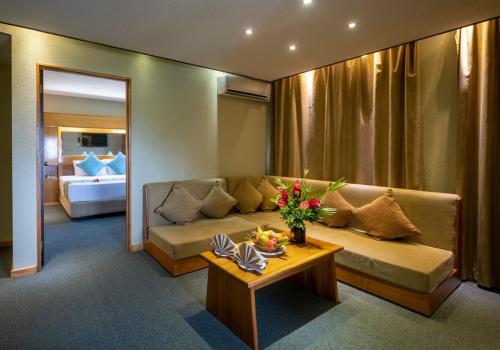 uma sala de estar com um sofá e uma mesa em Fiji Gateway Hotel em Nadi