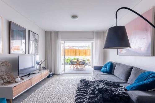 a living room with a couch and a television at Balmain Designer 1 Bedroom Apartment with Parking in Sydney
