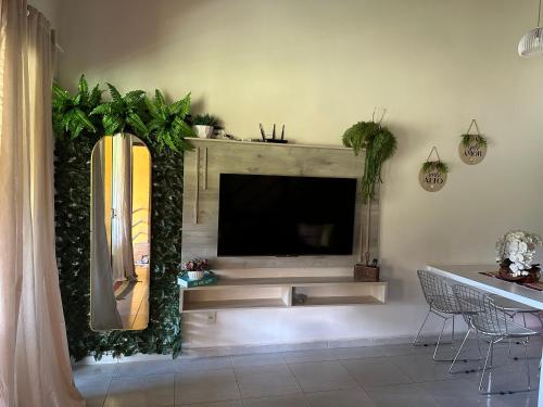 a living room with a large television in a wall at Flat Winterville Aconchegante próximo as piscinas in Gravatá