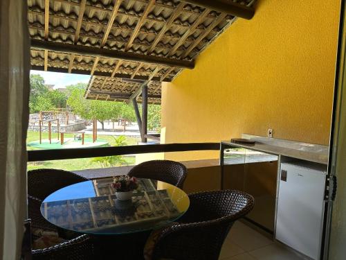 un tavolo e delle sedie in una cucina con una finestra di Flat Winterville Aconchegante próximo as piscinas a Gravatá