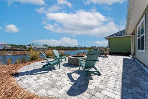 a patio with two green chairs and a fire pit at Minutes to Beach ,Golf Cart Included, Ocean View Pool ,Beach Equip, Ocean Therapy in Saint Joe Beach