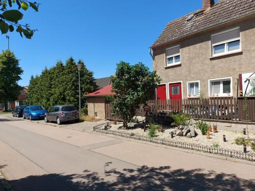 une maison avec une porte rouge dans une rue dans l'établissement Ferienwohnung 'Frühauf' im Südharz OT Uftrungen, 