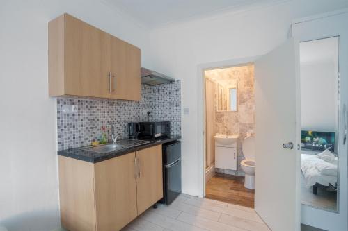 a small kitchen with a sink and a bathroom at Central London Stay in London