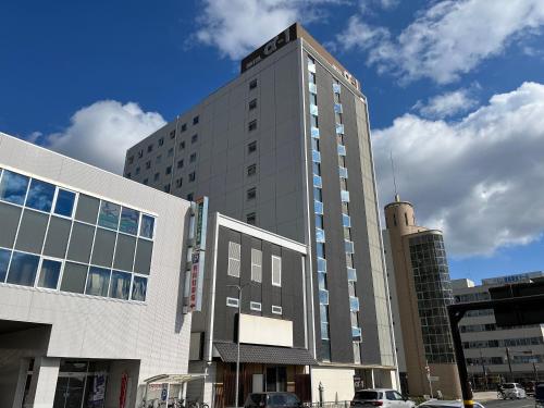 a tall building on a street with cars in front of it at Hotel Alpha-One Himeji Minamiguchi in Himeji