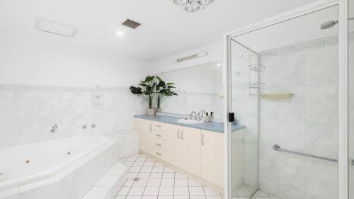 a bathroom with a tub and a sink and a shower at Nelson Bay CBD Apartment No 41 Nelson Towers in Nelson Bay