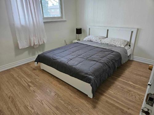 Łóżko w sypialni z drewnianą podłogą w obiekcie Charming 3 bedrooms detached house near the airport w mieście Mississauga