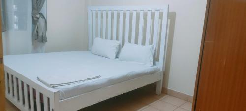 a white bed with two white pillows on it at Fancy One Bedroom Juja in Juja