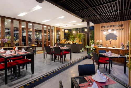a restaurant with tables and chairs and a sign that reads plectroprint at U Inchantree Kanchanaburi in Kanchanaburi