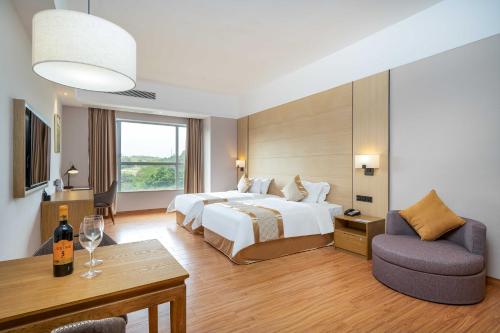 a large hotel room with a bed and a chair at Phoenix Hill Hotel Dongguan - Golf Course Shop in Tiantangwei