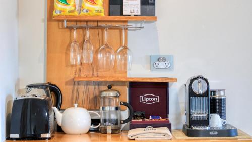 a kitchen counter with a coffee maker and wine glasses at The Madsen Boutique Hotel in Penguin
