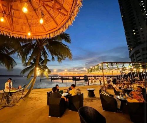 people sitting at tables on the beach at night at seaview beach 4-13pax/CIQ 5mins/ johor bahru ambersite in Johor Bahru