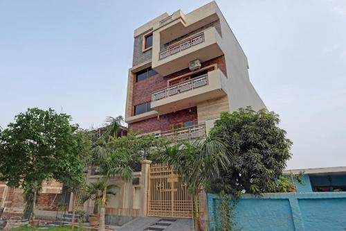 un edificio alto con una valla delante en OYO Stay 130, en Noida