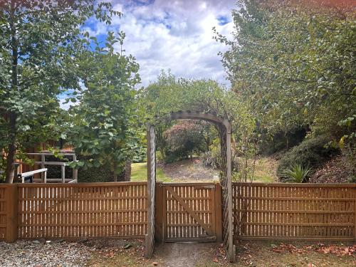 a wooden gate with an arch in a fence at Wanaka Springs Lodge in Wanaka
