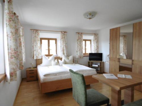 Achenmühle的住宿－Taffenreutherhof，一间卧室配有一张床、一张桌子和一张桌子