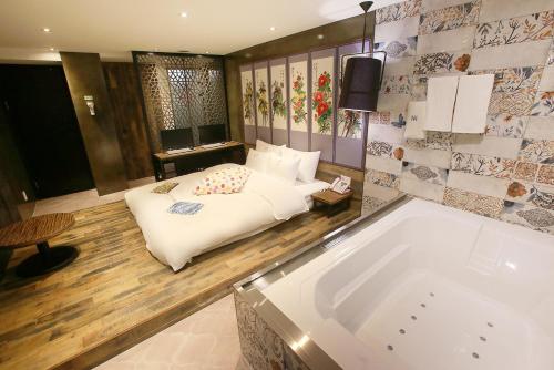 a bedroom with a bed and a bath tub at Hotel Yaja Jongno in Seoul