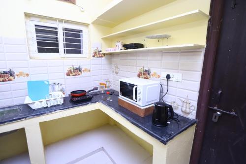 una cocina con encimera y microondas. en Lalitha Residency, en Secunderābād