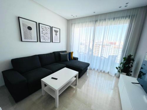 a living room with a black couch and a table at Luxury Apartments in Tangier