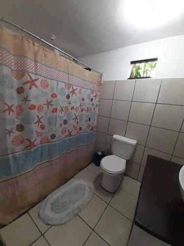 a bathroom with a toilet and a shower curtain at Casa Palos Verdes in Puerto Viejo
