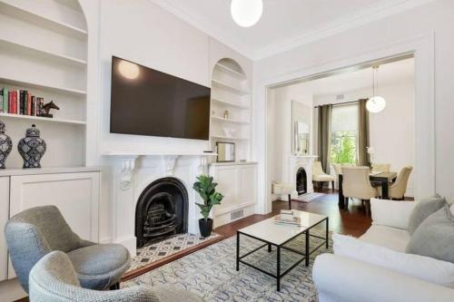a living room with a couch and a fireplace at Chic Large 4 Bedroom Barangaroo The Rocks Sydney in Sydney