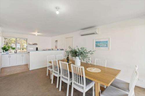 a kitchen and dining room with a wooden table and chairs at Strandhytta 10 Cant Rd Goolwa South - No Linen Included in Goolwa South