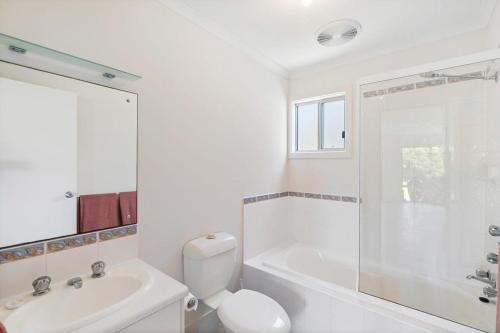 a white bathroom with a toilet and a sink at Strandhytta 10 Cant Rd Goolwa South - No Linen Included in Goolwa South