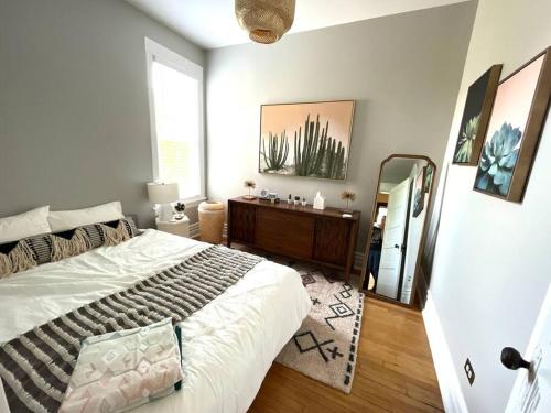 1 dormitorio con 1 cama grande y espejo en Irving Park/Avondale updated vintage top unit 2-flat, en Chicago