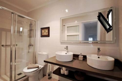 a bathroom with a toilet and a sink and a mirror at Acacias Home Arrecife in Arrecife