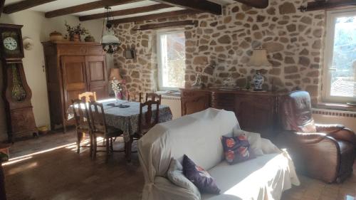 un salon avec un canapé et une table dans l'établissement Le Mas des Mûriers en Cévennes gardoises, à Gagnières