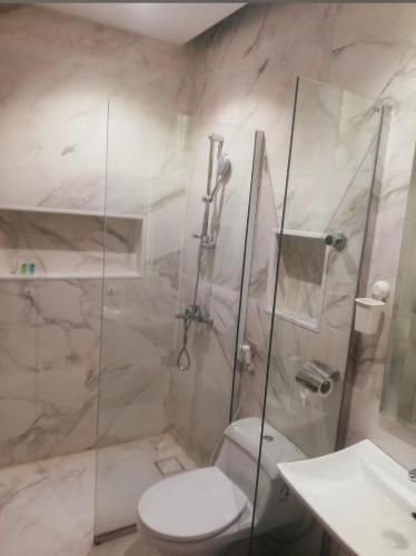 een badkamer met een douche, een toilet en een wastafel bij شاليهات درة بارك الشقيق in Ash Shuqayq