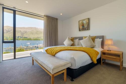 una camera con un grande letto e una grande finestra di Marina Terrace, Wanaka a Wanaka