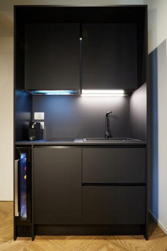a kitchen with black cabinets and a sink at Palazzina RIVA in Venice